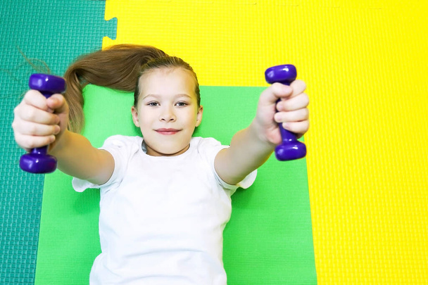 Kleines Mädchen treibt Sport in besonders engen Kleidern im Kinderzentrum und führt einen gesunden Lebensstil - Foto, Bild
