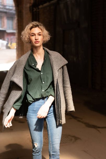 jovem bela mulher posando de fora em um casaco e jeans - Foto, Imagem