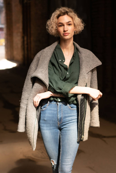jovem bela mulher posando de fora em um casaco e jeans - Foto, Imagem