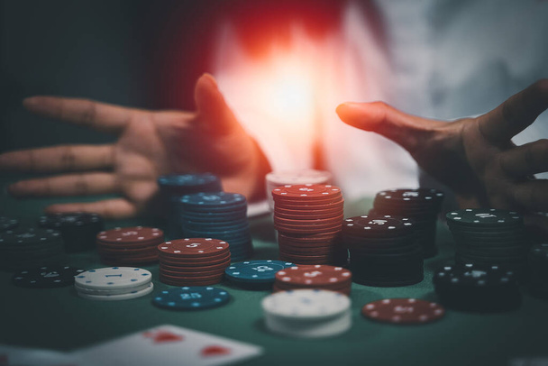 Ασιάτισσα έμπορος ή κρουπιέρης ανακατεύει τα χαρτιά του πόκερ σε ένα καζίνο στο παρασκήνιο ενός τραπεζιού, asain γυναίκα κρατώντας δύο τραπουλόχαρτα. Καζίνο, πόκερ, πόκερ έννοια παιχνιδιού - Φωτογραφία, εικόνα