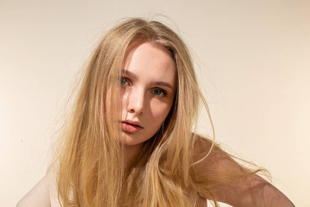 Bílá mladá žena s blond vlasy izolované na béžové - Fotografie, Obrázek