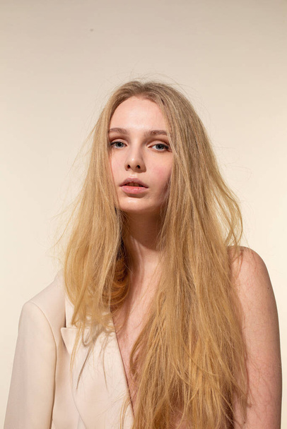 White young woman with blonde hair isolated on beige in beige blazer - Φωτογραφία, εικόνα