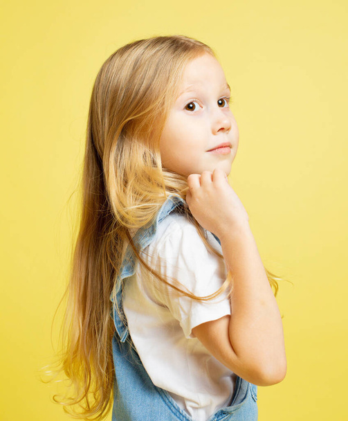 White european baby girl with blonde hair isolated on yellow - Φωτογραφία, εικόνα