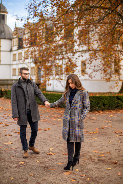White young european married couple with building behind in autumn - Foto, immagini