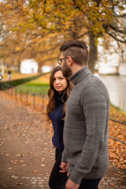 Wandelen jong europees getrouwd paar in park in de herfst - Foto, afbeelding