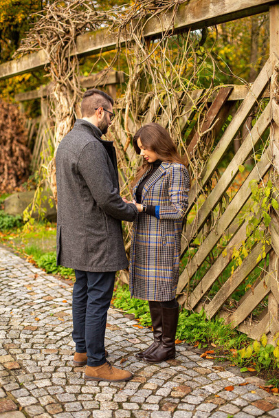 White young european married couple near fence in autumn - Foto, afbeelding