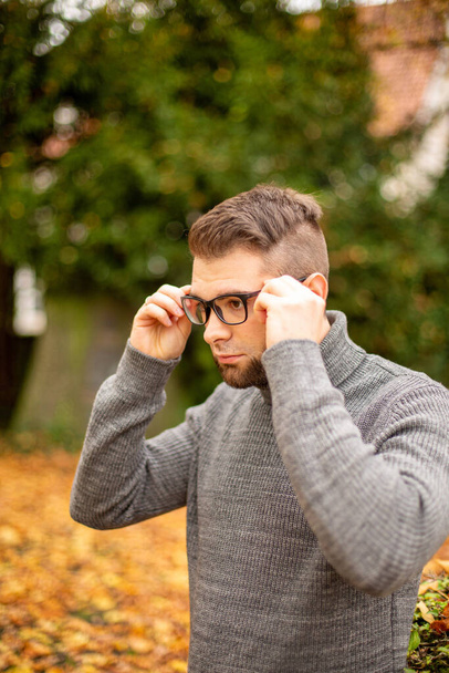 Bespectacled white young european man in park in autumn - Fotografie, Obrázek