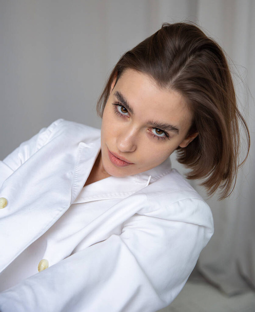 Portrait of white european woman with bob cut in white suit - Foto, afbeelding