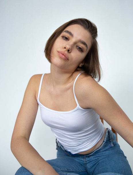 White european woman with bob cut on white in a top and blue jeans - Foto, immagini