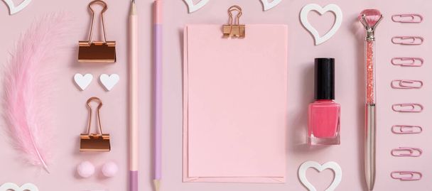 Pinkfarbene Papierkarte mit Clip, mädchenhaften Accessoires und Herzen auf pastellrosa Draufsicht, Kartenattrappe leer. Freundlicher Arbeitsplatz. Zurück zur Schule und zum Valentinstag - Foto, Bild