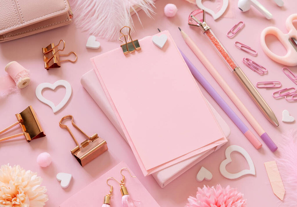 Tarjeta de papel rosa con clip, accesorios de niña de la escuela y corazones en rosa pastel de cerca, maqueta de tarjeta en blanco. Trabajo femenino. Conceptos de regreso a la escuela y día de San Valentín - Foto, Imagen