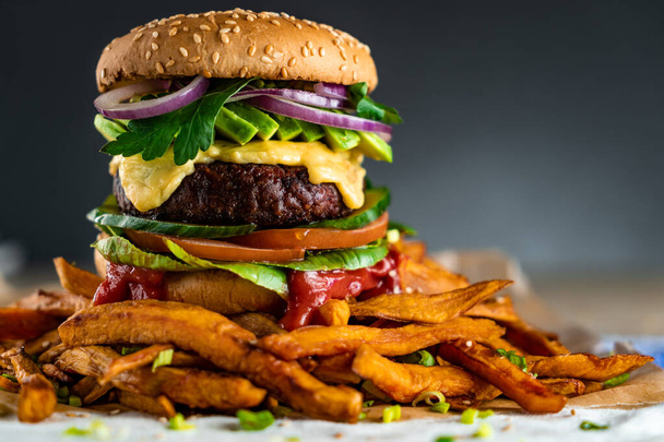 Hamburger fatto in casa a base di piante con patatine fritte intorno. Vegano. - Foto, immagini