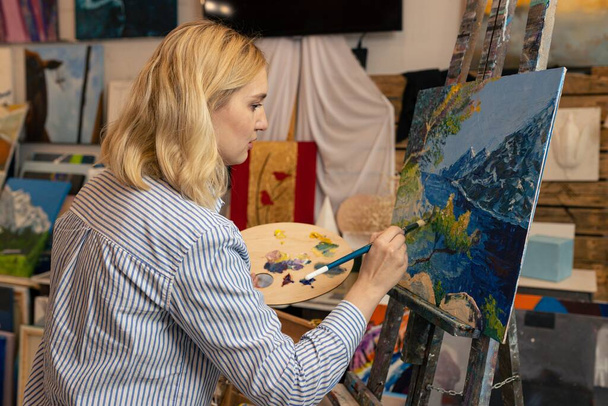 Молода жінка малює картину в студії
 - Фото, зображення