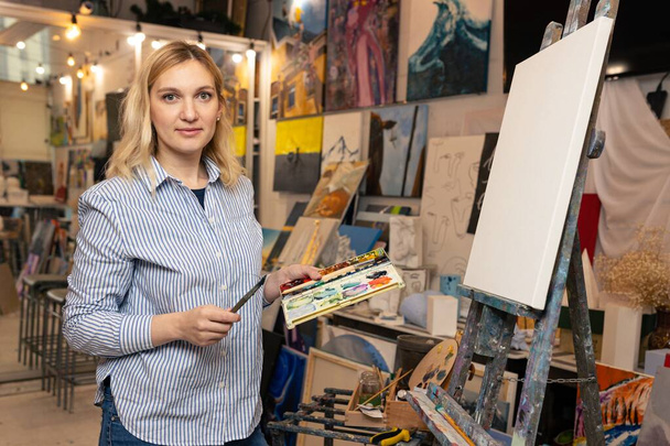Nuori naistaiteilija alkaa maalata kuvaa taidestudiossa - Valokuva, kuva