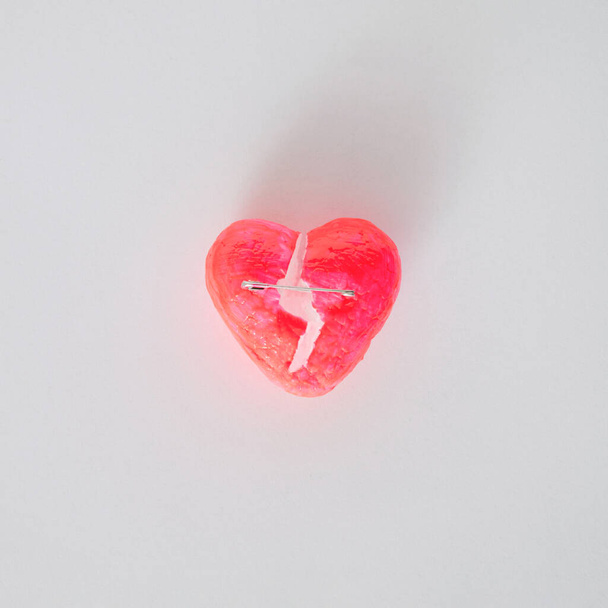 Srdce pulzující růžový střih uprostřed a spojené bezpečnostní pin.Valentine koncept lásky design idea.Flat ležel na bílém pozadí - Fotografie, Obrázek