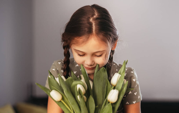 Portret van een mooi meisje met witte bloemen tulpen. Ind - Foto, afbeelding