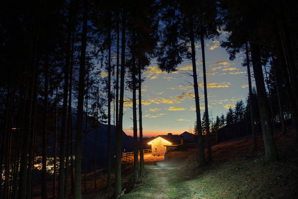 Πέτρινο εξοχικό σπίτι στο βουνό φωτίζεται με τεχνητό φως, - Φωτογραφία, εικόνα