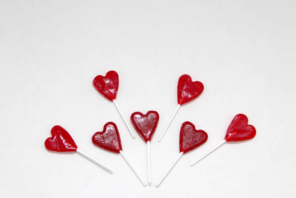 Roter herzförmiger Bonbon-Lutscher als Geschenk zum Valentinstag der Liebe und Freundschaft als Grußkarte auf weißem Hintergrund - Foto, Bild