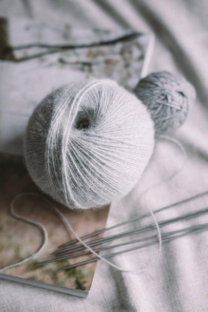 Boules de fil de laine avec aiguilles sur un fond rustique. Concept pour la vie lente à la main et hygge.   - Photo, image