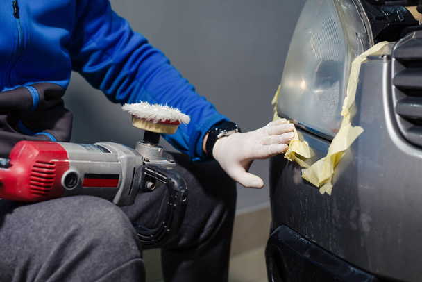 Gloved human hands placing a paste on a sponge from a polishing tool to polish car headlights - Fotó, kép