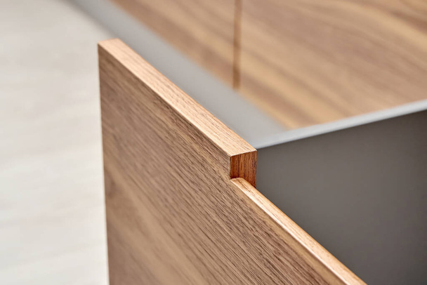 Open drawer of dark grey color with facade of walnut wood with finger pull design in contemporary kitchen extreme close-up - Φωτογραφία, εικόνα