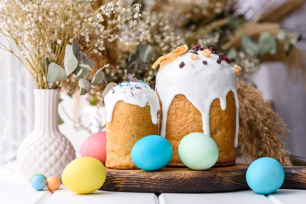 Húsvéti torta és húsvéti tojás ünnepi asztal beállítása hagyományos dekoráció és kezeli. Boldog húsvét ünnep az asztalon étkezés snack kültéri felső nézet másolás tér élelmiszer háttér rusztikus - Fotó, kép