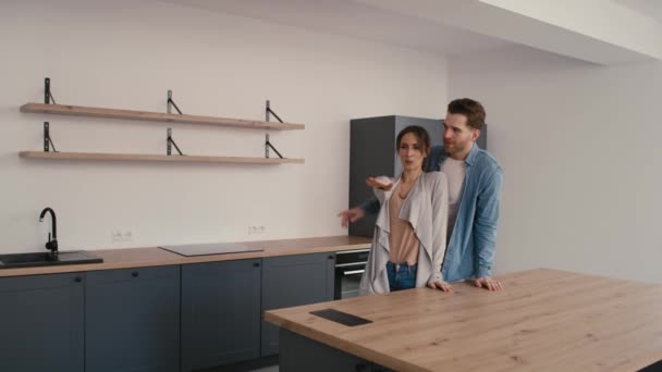 Blank echtpaar erg enthousiast tijdens het kijken naar hun nieuwe huis. Opgenomen met RED helium camera in 8K. - Video