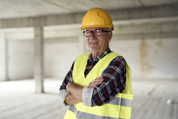 Senior caucasian man holding plans on the construction site  - Фото, зображення