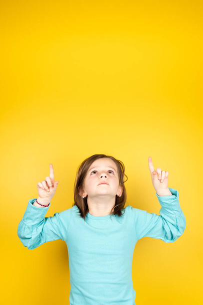 Kid pointing up to yellow copy space - Zdjęcie, obraz