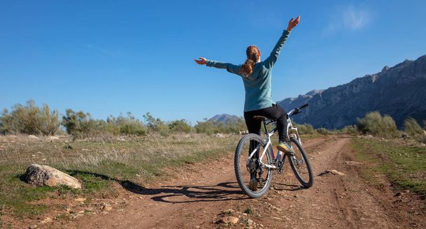 happy woman on mountain bike in countryside - Фото, зображення