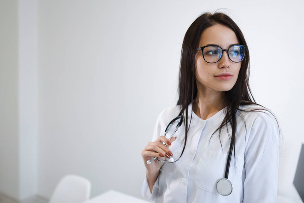 Portrait of female medic with stethoscope. Beautiful young nurse with glasses - Zdjęcie, obraz