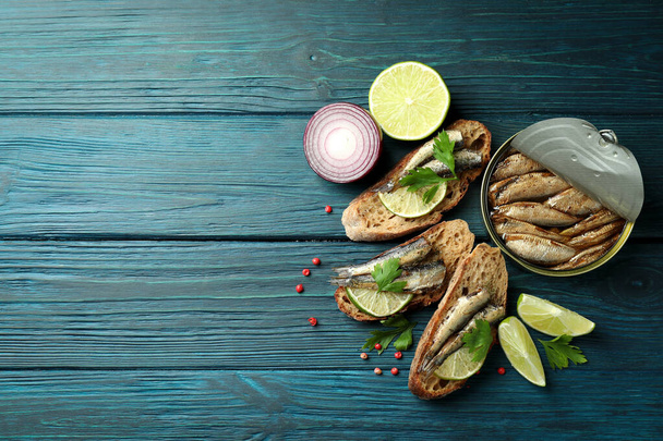 Concepto de sabroso snack con sándwiches con espadines sobre fondo de madera - Foto, imagen
