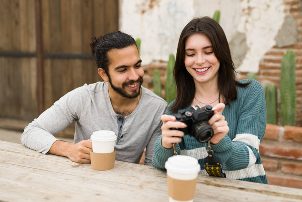 Eccitato coppia multirazziale scattare foto con una macchina fotografica e sorridente mentre si gode un caffè  - Foto, immagini