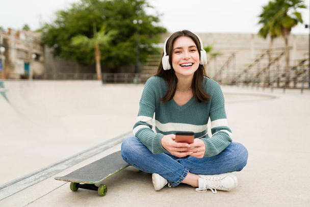 Miluju skateboarding. Veselý mladý žena těší její den na skatepark  - Fotografie, Obrázek