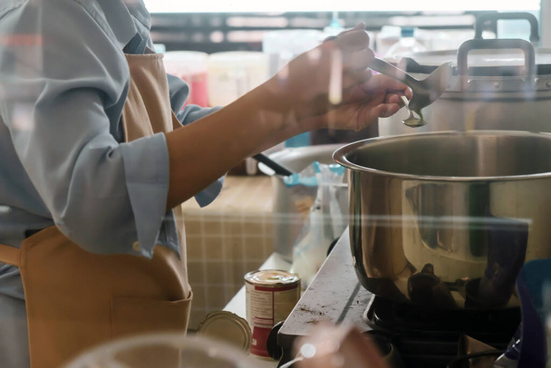Imagen de la mujer preparando comida en la estufa - Foto, imagen