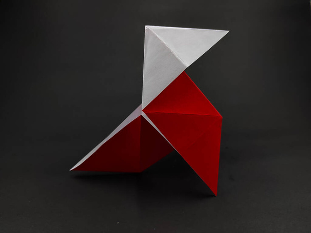 Rotes Origami aus der Money-Heist-Serie isoliert auf schwarzem Hintergrund - Foto, Bild