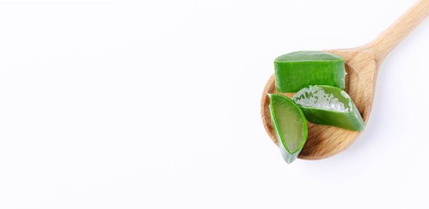 Fette di aloe vera in un cucchiaio di legno su sfondo bianco. Aloe vera per cosmetici naturali e medicina alternativa. - Foto, immagini