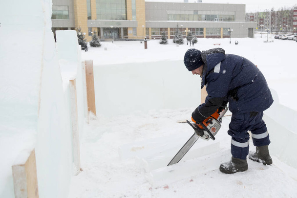 Pracownik budowlany piły płyty lodu z piłą łańcuchową - Zdjęcie, obraz