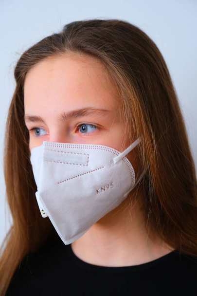 Coronavirus. The girl is quarantined because of the coronavirus in a protective mask. Concerned about viral pandemic illness, paranoid of pandemic. - Photo, image