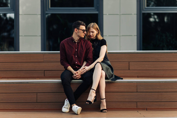 Romantic couple in love look at each other, on vacation enjoy moments of happiness. man and woman are sitting on the stairs outdoors enjoying time together. dating, romance. Valentine's Day - Valokuva, kuva