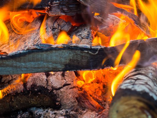 Un feu ardent. Le feu brûle dans la forêt. Texture des charbons ardents. Feu de camp pour cuisiner dans la forêt. brûlant des branches sèches. - Photo, image