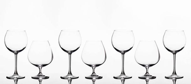 Vaciar vasos de vino sobre un fondo blanco. hermosa naturaleza muerta. Coñac y copas de vino. cartel de arte - Foto, imagen