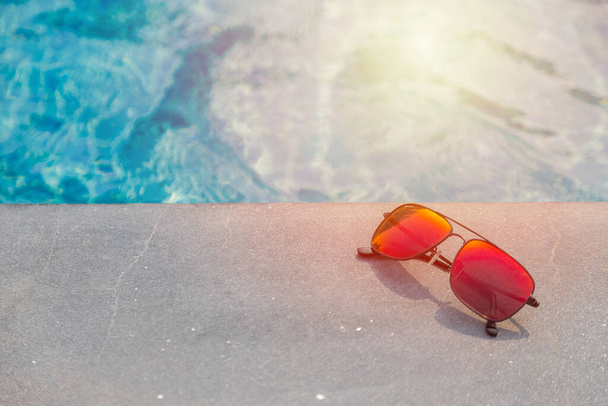 Fashion zonnebril in de buurt van het zwembad achtergrond - Foto, afbeelding