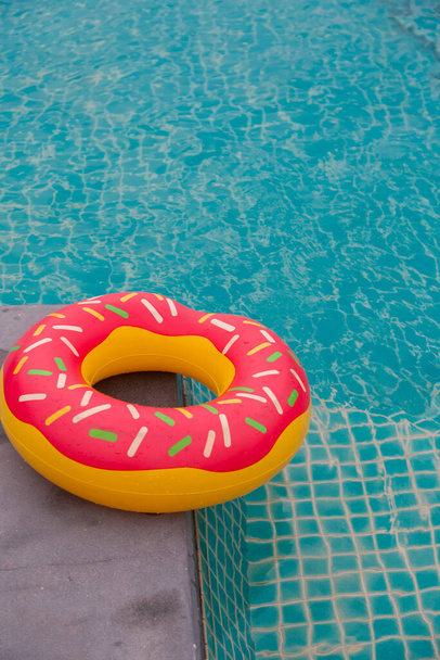Rubber ring in blauw zwembad achtergrond - Foto, afbeelding