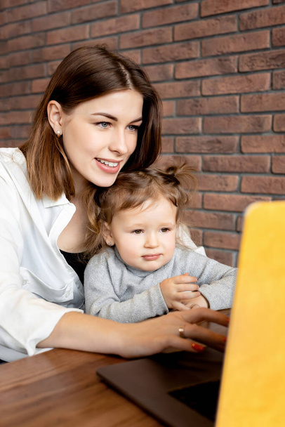 mother and daughter with laptop  at desk  - Fotó, kép