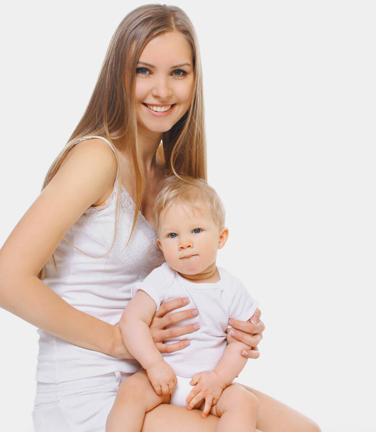 Ritratto di allegra madre sorridente e bambino che giocano insieme su uno sfondo bianco - Foto, immagini