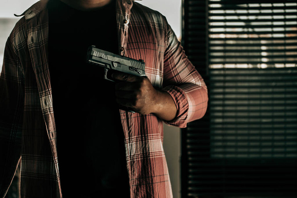 A thief in a striped shirt with a gun breaks through the door of the robber concept. - Foto, Imagen
