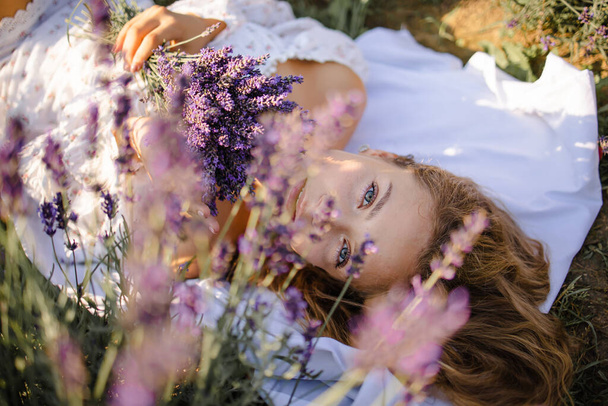 Blonde girl in lavender fields in Provence in spring or summer field with Boho style clothing - Foto, Imagen