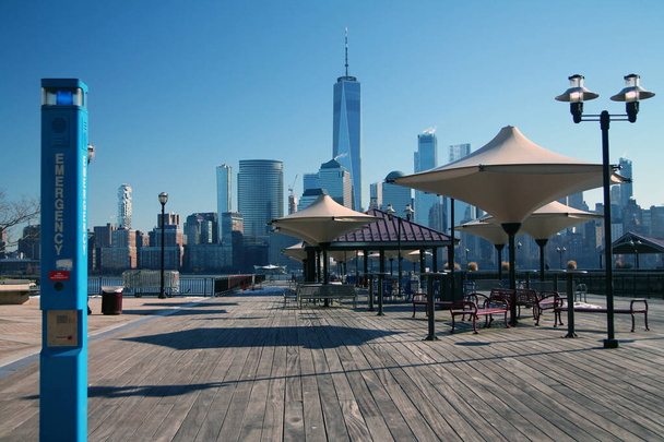 Die blaue Notrufsäule auf einem Holzsteg mit Blick auf Downtown Manhattan von Waterfront New Jersey - Foto, Bild