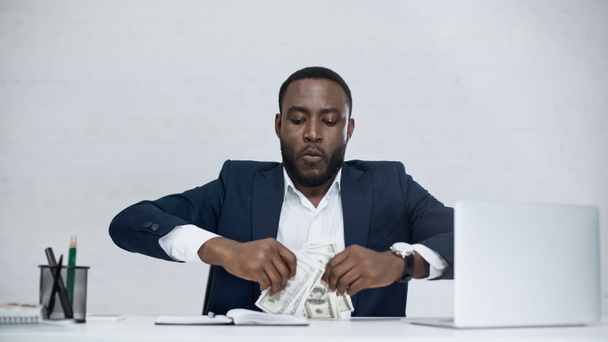 african american businessman holding dollar banknotes isolated on grey - Fotó, kép